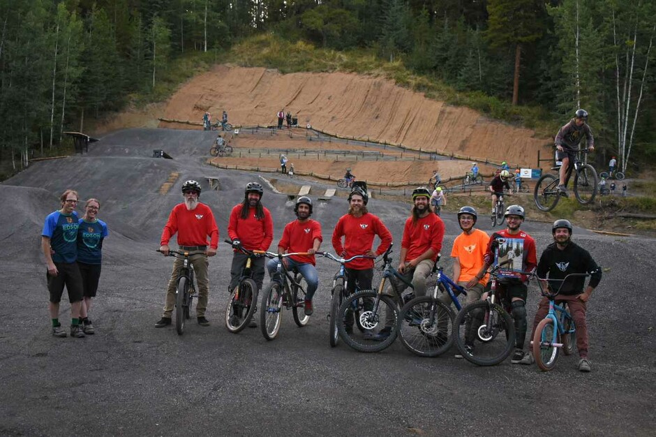 a group or bike riders sitting on their bikes in front of a bike park