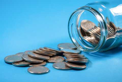 coins spilling out of a tipped over jar